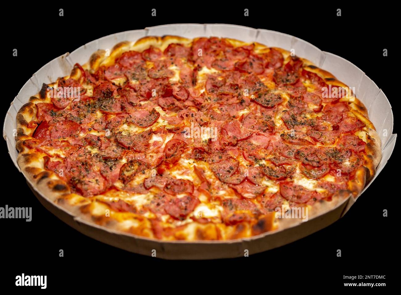 The most traditional pepperoni pizza isolated on a black background. Calabresa pizza Stock Photo