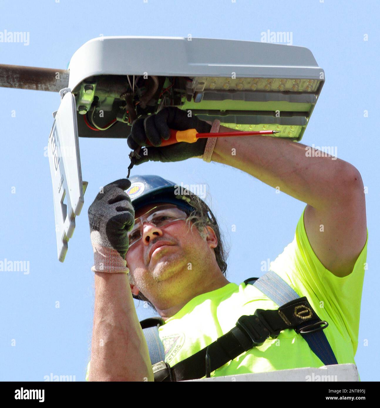 Jason Eckert of West Side Hammer Electric disconnects old street light