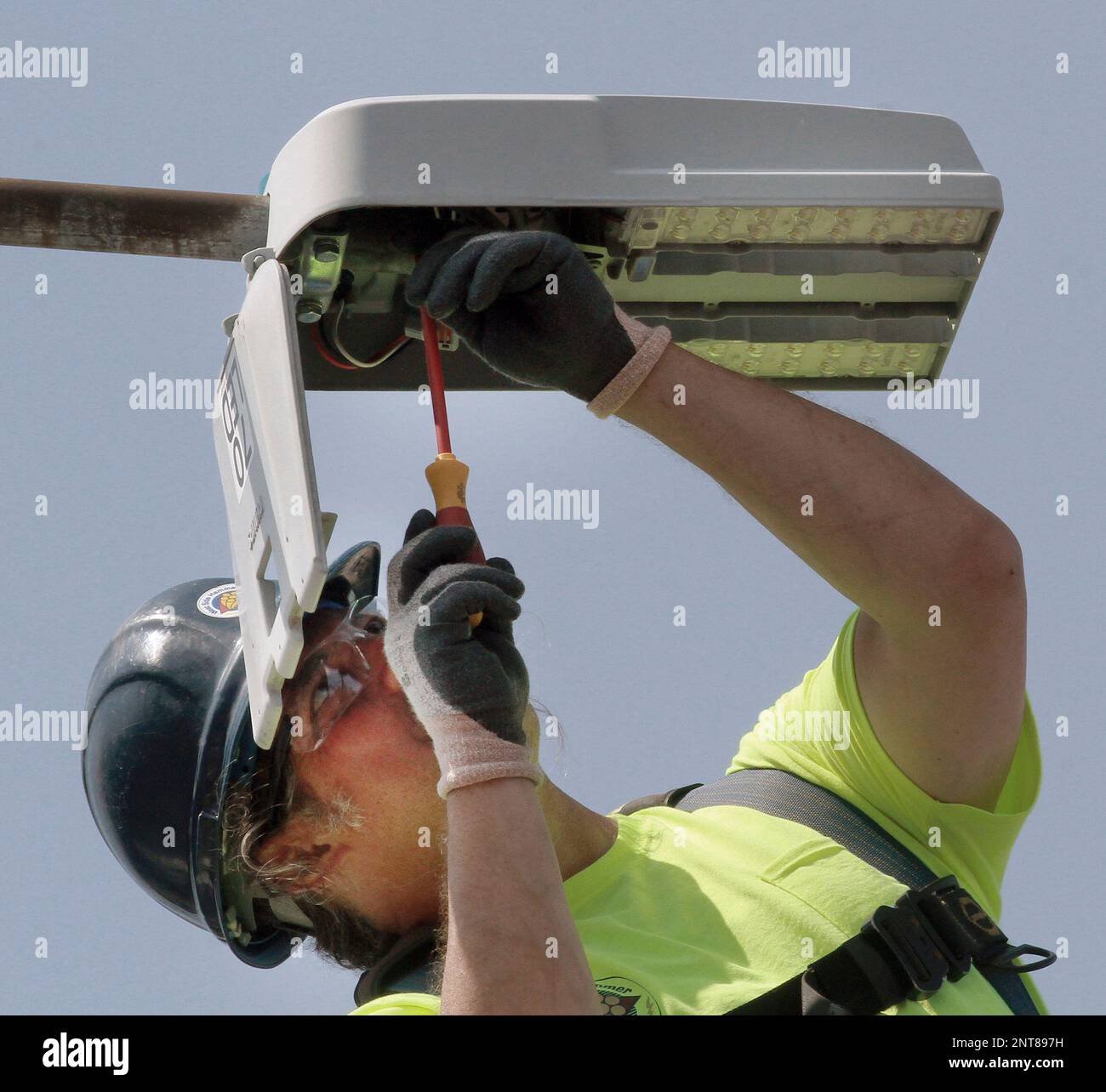 Jason Eckert of West Side Hammer Electric disconnects old street light