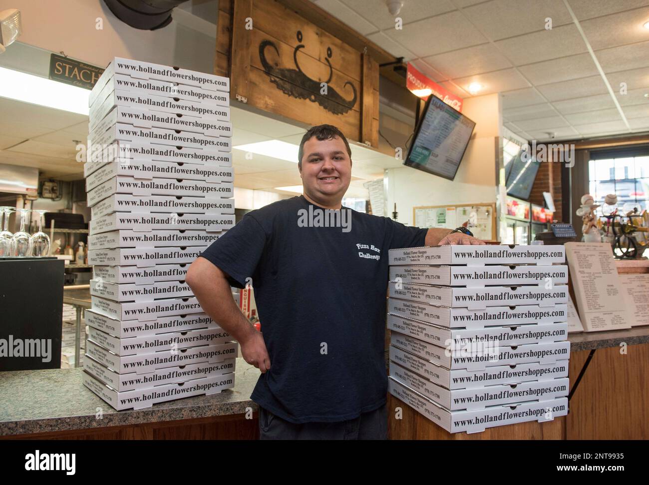 This photo taken June 28, 2019, shows Andrew Chartier, 19, posing with pizza boxes he folded at