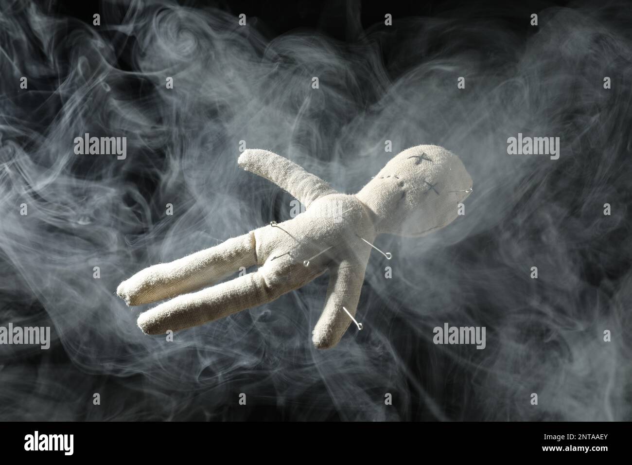 Voodoo doll with pins and smoke on dark background Stock Photo - Alamy