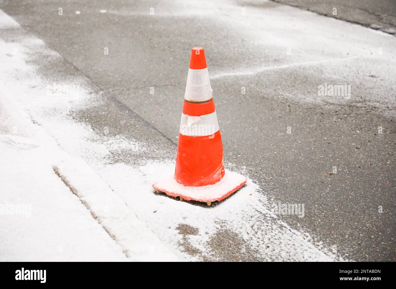 Construction cone in the street sidewalk showing caution during traffic Stock Photo