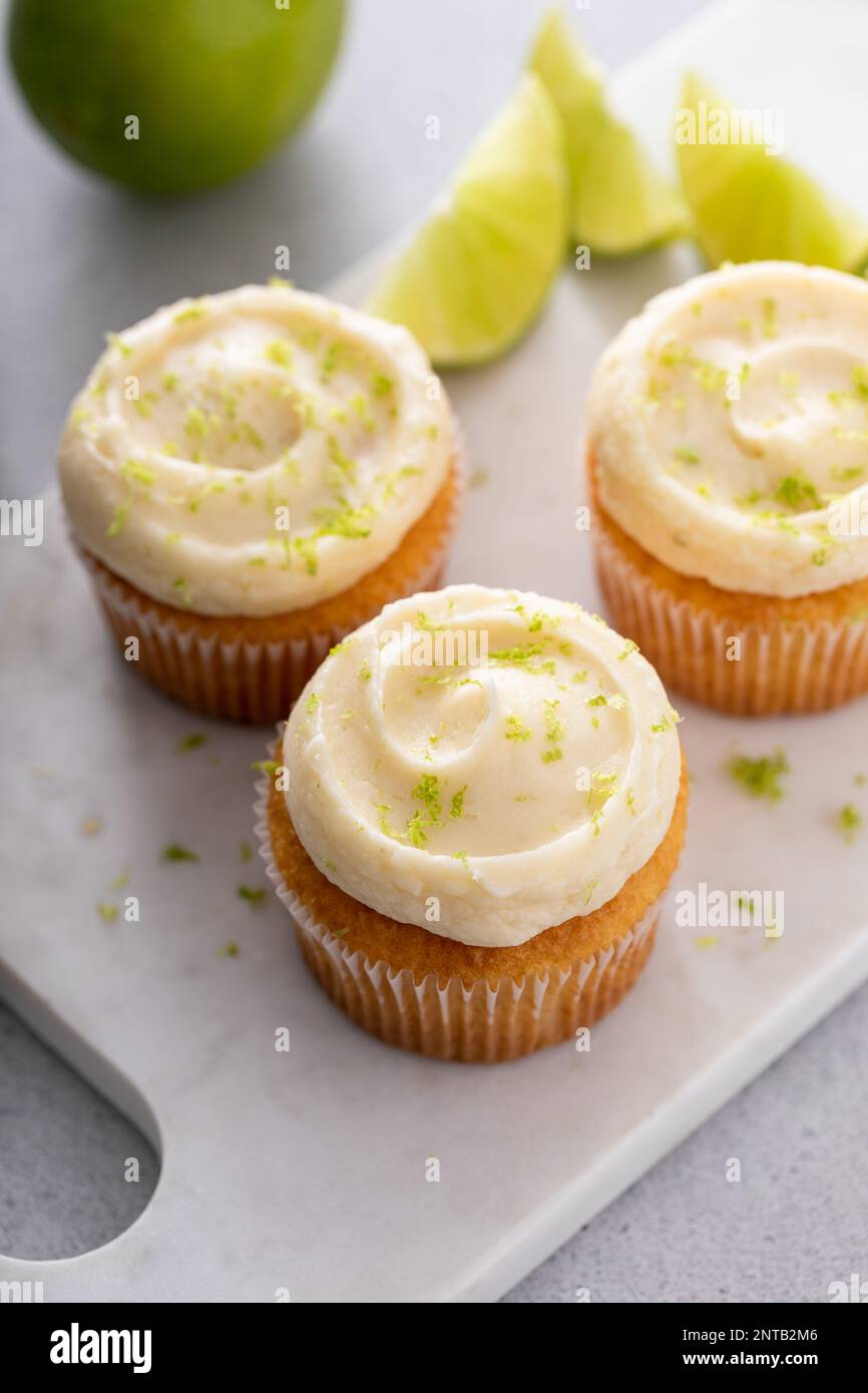 Coconut and key lime cupcakes on serving board, key lime pie inspired ...