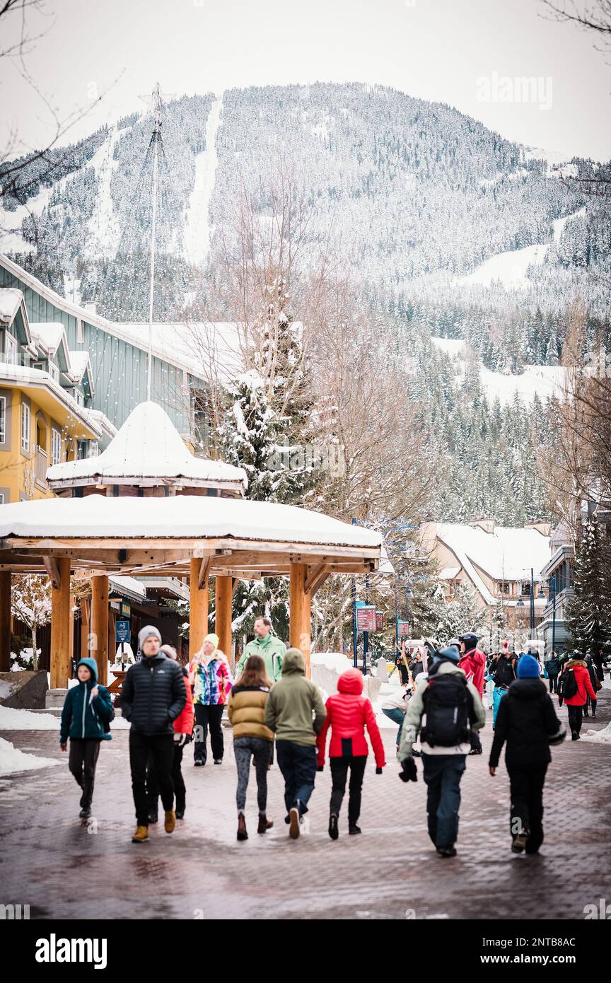 Tourists walk through the Whistler Village on a snowy winter afternoon.  Whistler BC, Canada. Stock Photo