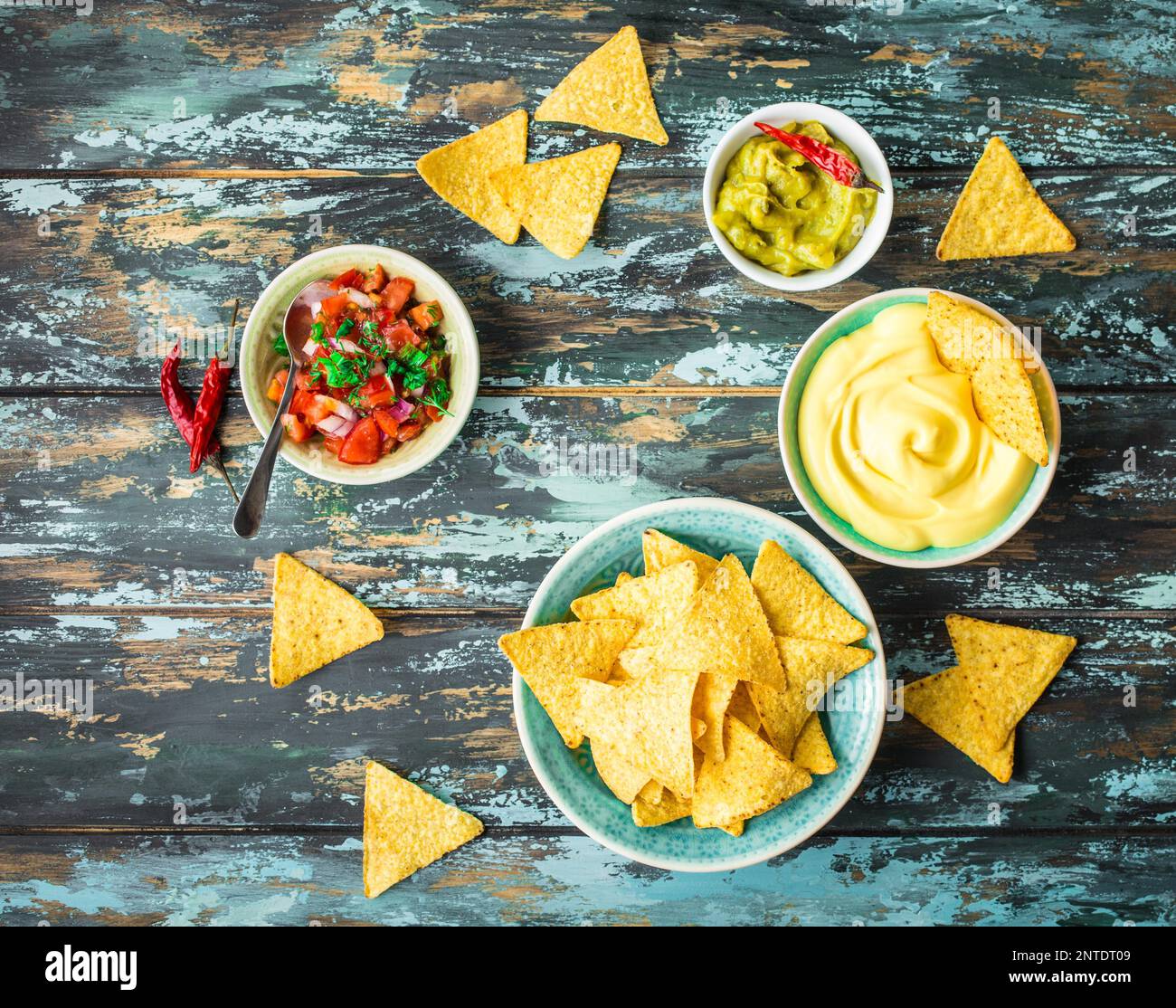 Mexican tortilla chips with guacamole, cheese, salsa dips. Nachos and