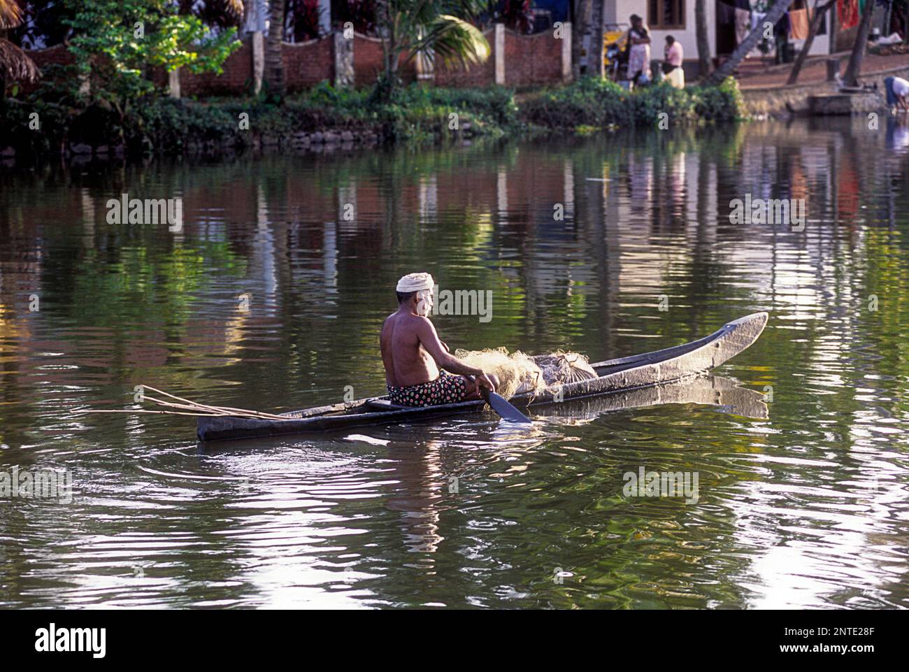 Fisherman in a small wooden boat, Backwaters of Kuttanad, Alappuzha, Alleppey, Kerala, India, Asia Stock Photo