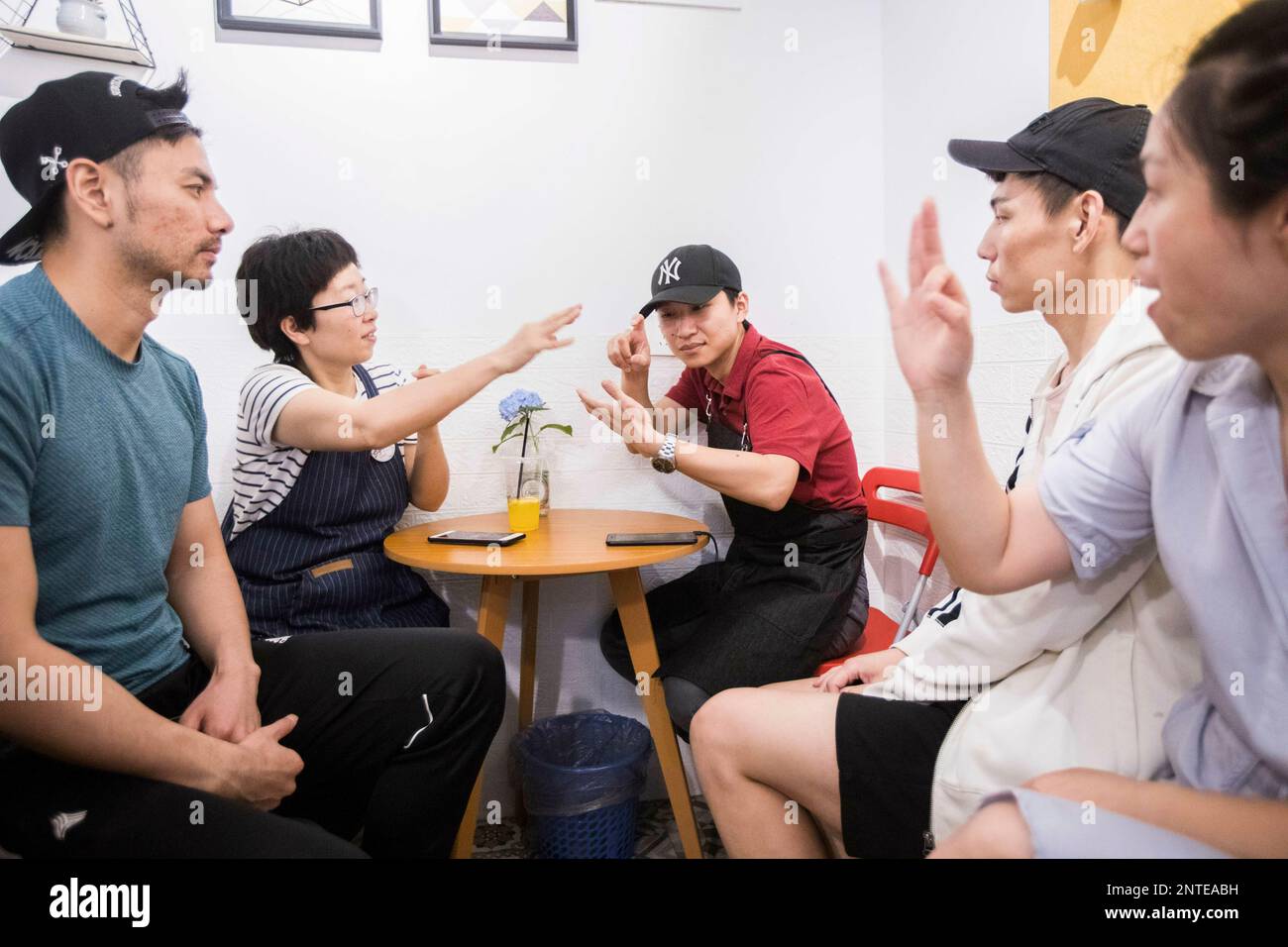The deafandmute barista Lu Jun, center, speaks with customers in sign