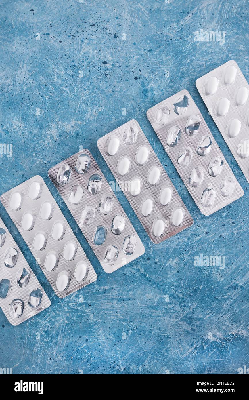 multivitamins pills or medicine tablets into blister packs next to other empty ones, concept of healthcare prescription and nutritional supplements Stock Photo