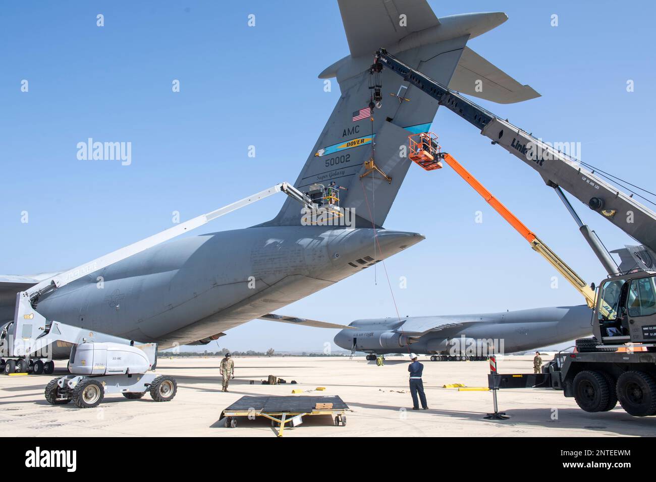 NAVAL STATION ROTA, Spain (Feb. 22, 2023) Seabees assigned to Naval Mobile Construction Battalion (NMCB) 1, NMCB 11, and Air Force Personnel from the 436th Maintenance Squadron (MXS), lift and install a new tail rudder on a C5 Super Galaxy. This maintenance evolution is the first time it had been completed outside of Dover Air Force Base. NMCB 1 operates as a part of Navy Expeditionary Combat Command and is assigned to Commander, Task Force 68 for deployment across the U.S. Naval Forces Europe-Africa area of operations to defend U.S., allied, and partner interests. (U.S. Navy photo by Mass Com Stock Photo