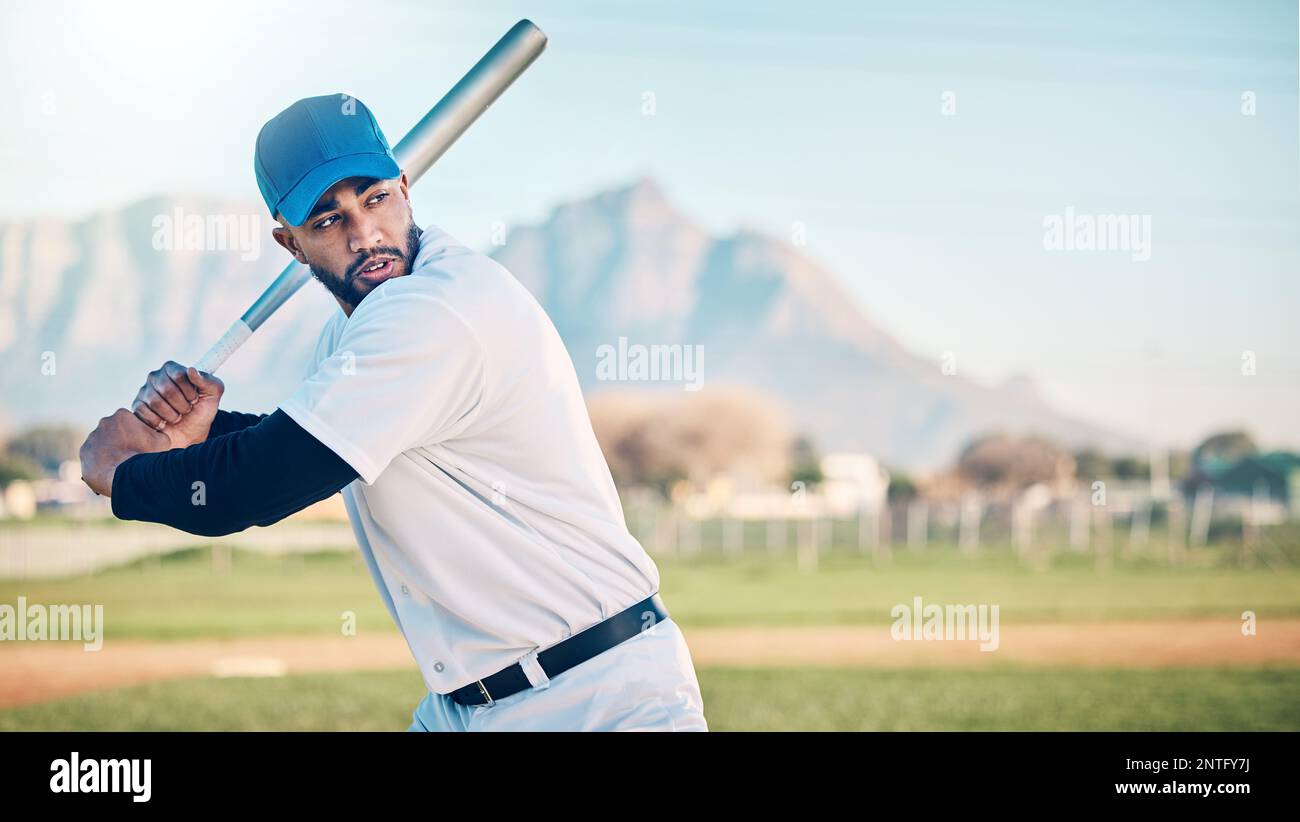 Baseball swing, athlete and mountains of a professional player from Dominican Republic outdoor. Sport field, bat and sports helmet of a man doing Stock Photo
