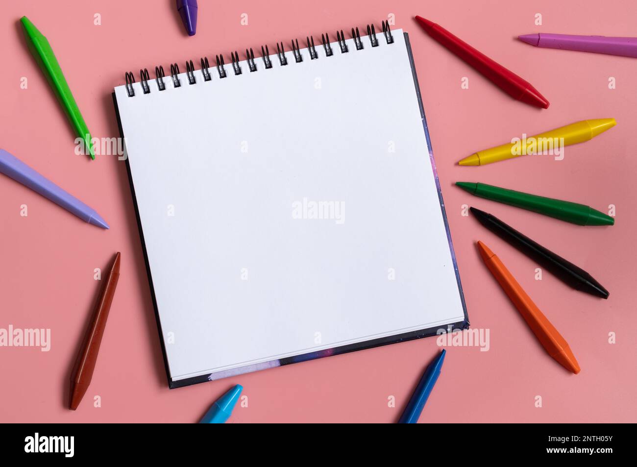 https://c8.alamy.com/comp/2NTH05Y/open-sketchbook-with-white-empty-blank-colorful-wax-crayons-on-the-pastel-pink-background-flat-lay-composition-back-to-school-concept-art-therapy-2NTH05Y.jpg