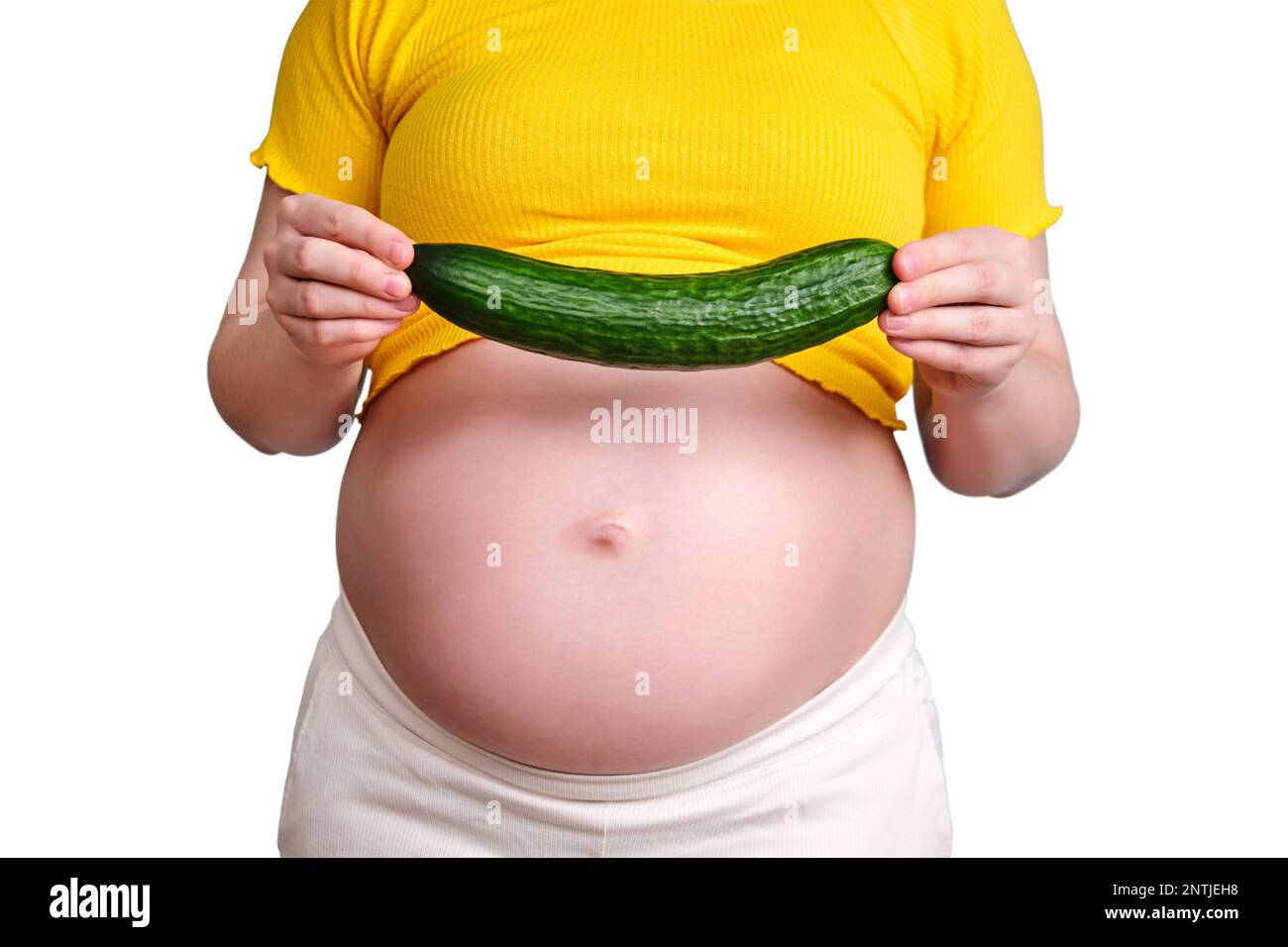 A green cucumber in the hands of a pregnant woman, isolated on a white