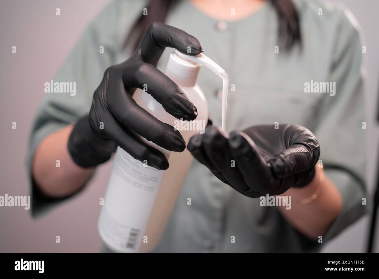 sugaring master wearing black gloves putting a lotion on her