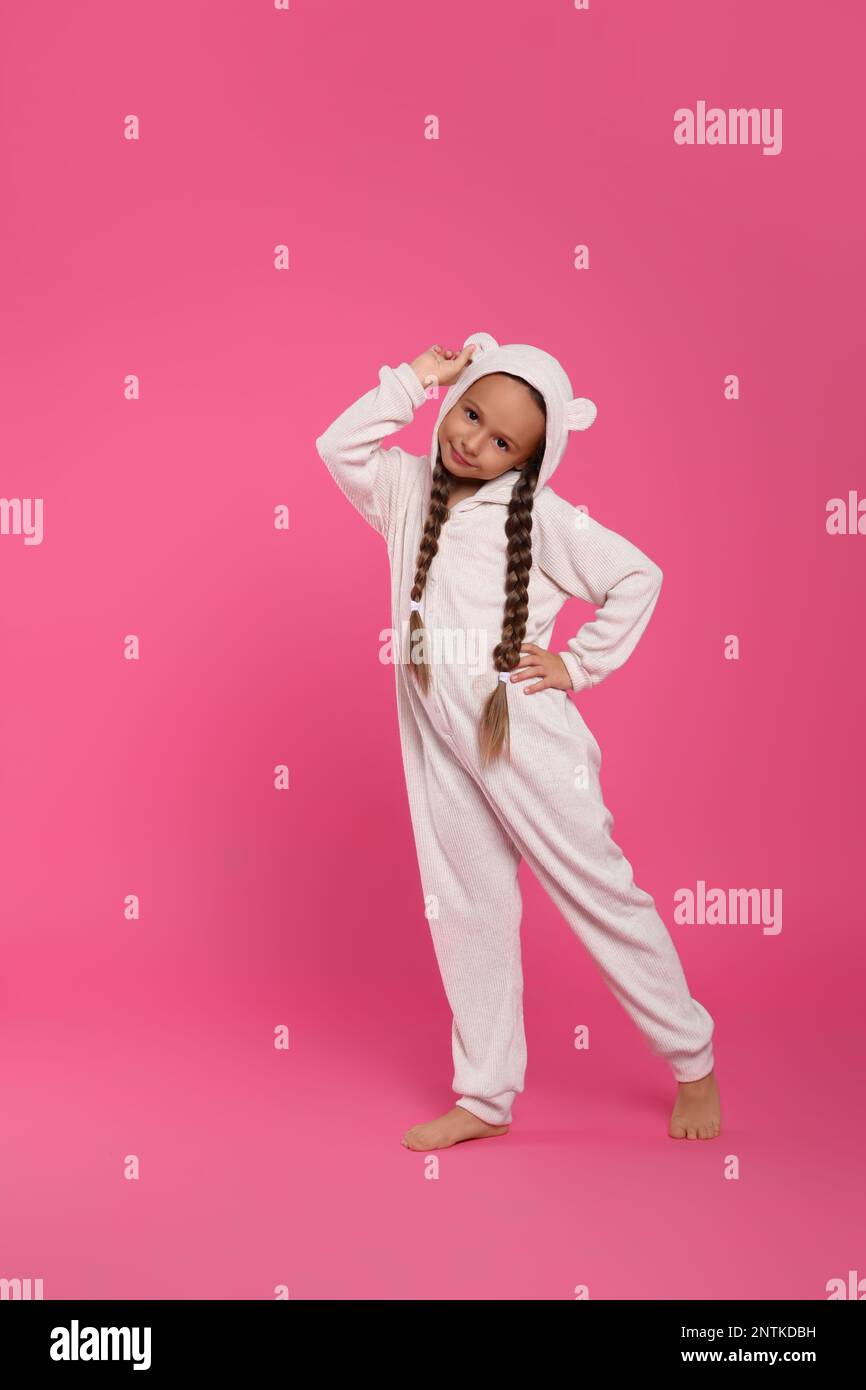 Cute girl wearing pajamas on pink background Stock Photo - Alamy