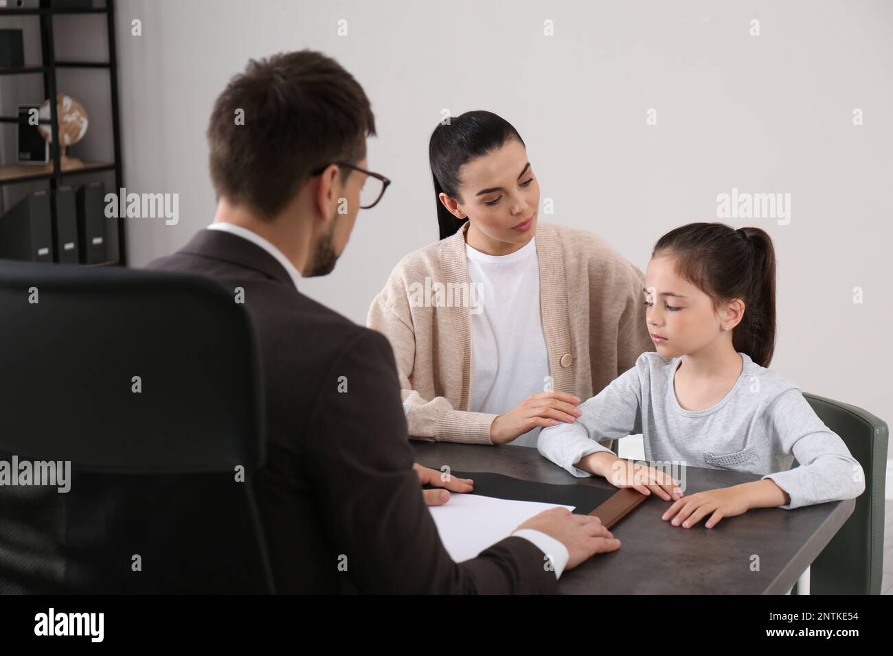 Mother and daughter having meeting with principal at school Stock Photo