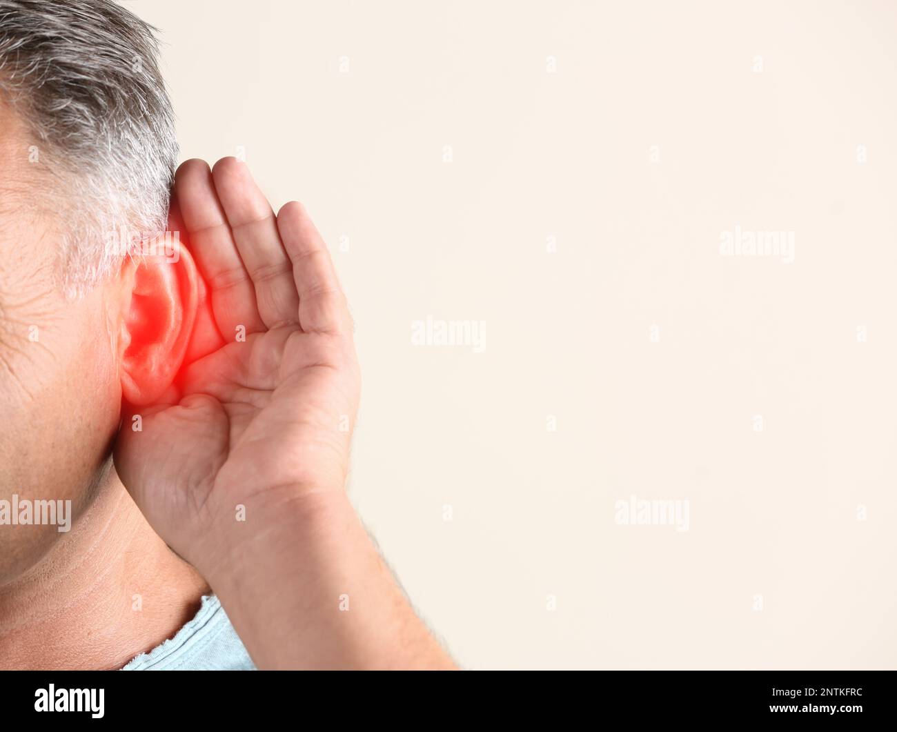 Mature man suffering from earache on light background, closeup. Space for text Stock Photo
