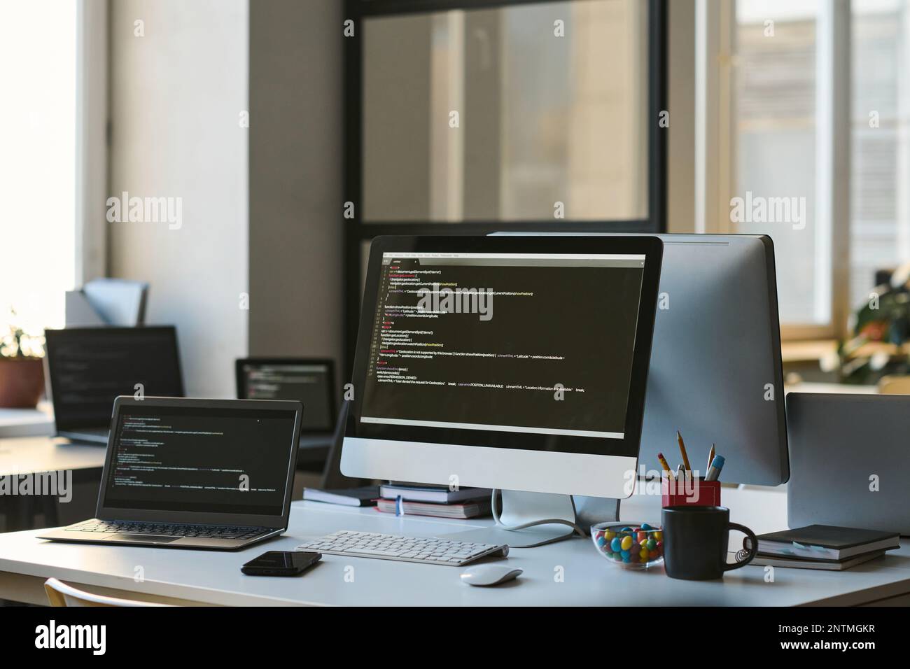 Modern workplace of developer with computers with programming codes on ...