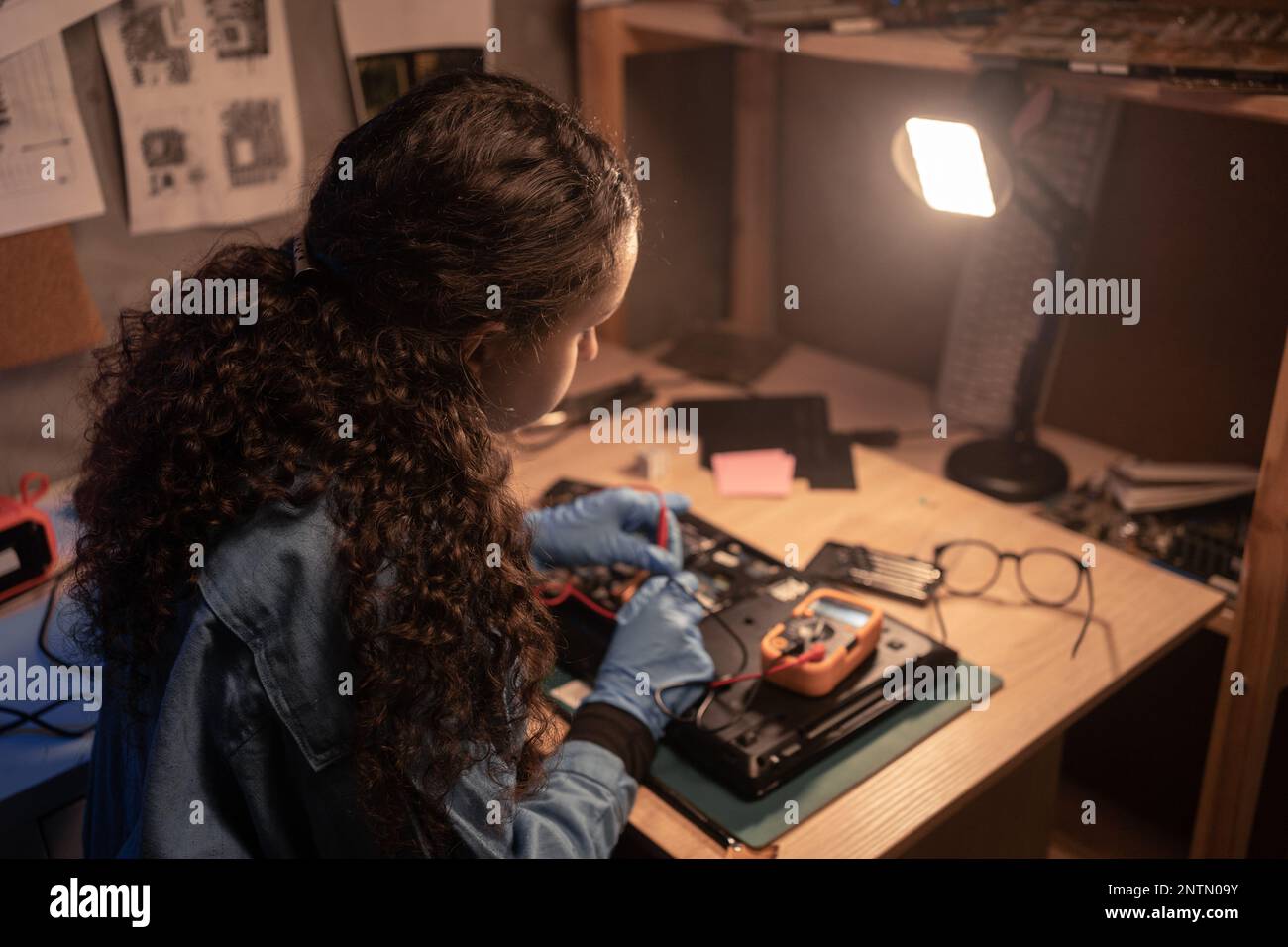 Computer retro repair shop. Female engineer performing laptop