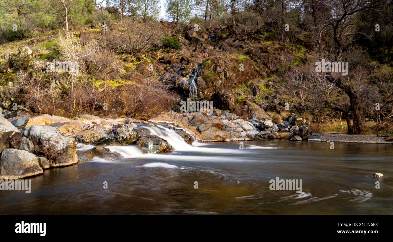 A landscape of a stream with long exposure surrounded by rocks and ...