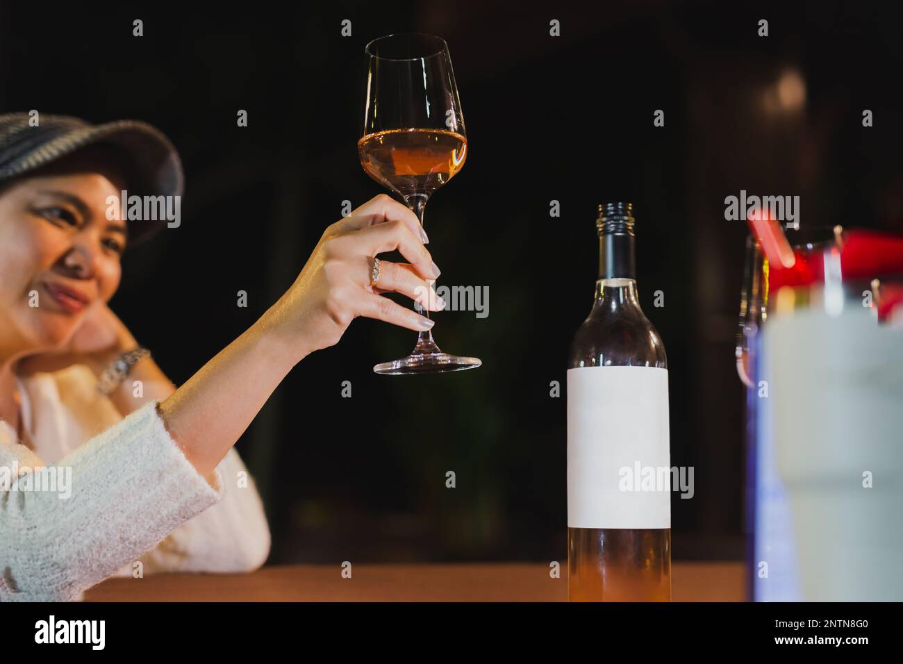 Happy woman holding glass of wine relaxing in restaurant Stock Photo ...