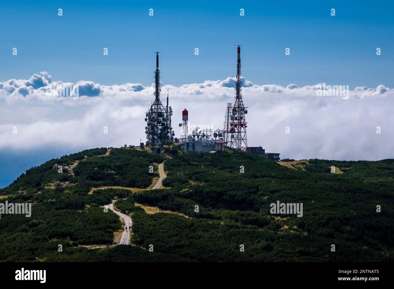 Telecommunication station on the top of the Cima Paganella mountain, the valley below full of clouds. Stock Photo