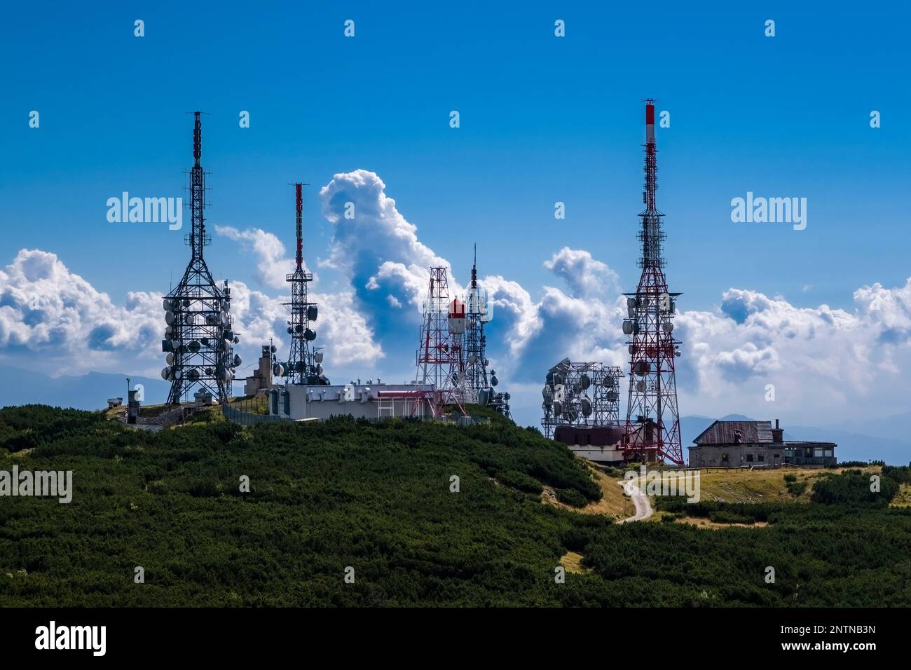 Telecommunication station on the top of the Cima Paganella mountain, storm clouds building up behind. Stock Photo