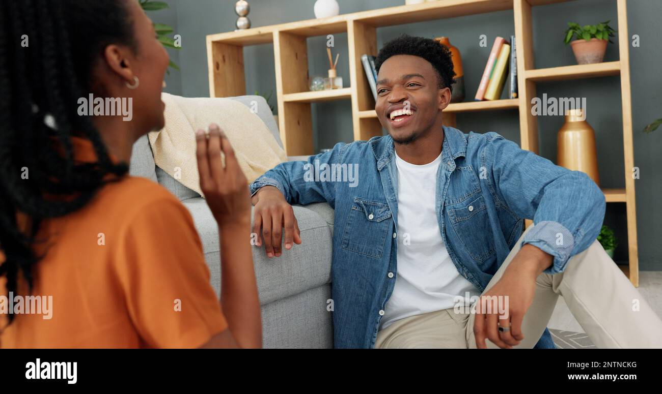 Funny couple eating popcorn for game in living room, comic on date night and smile for black people love in house. Comedy, communication and crazy man Stock Photo