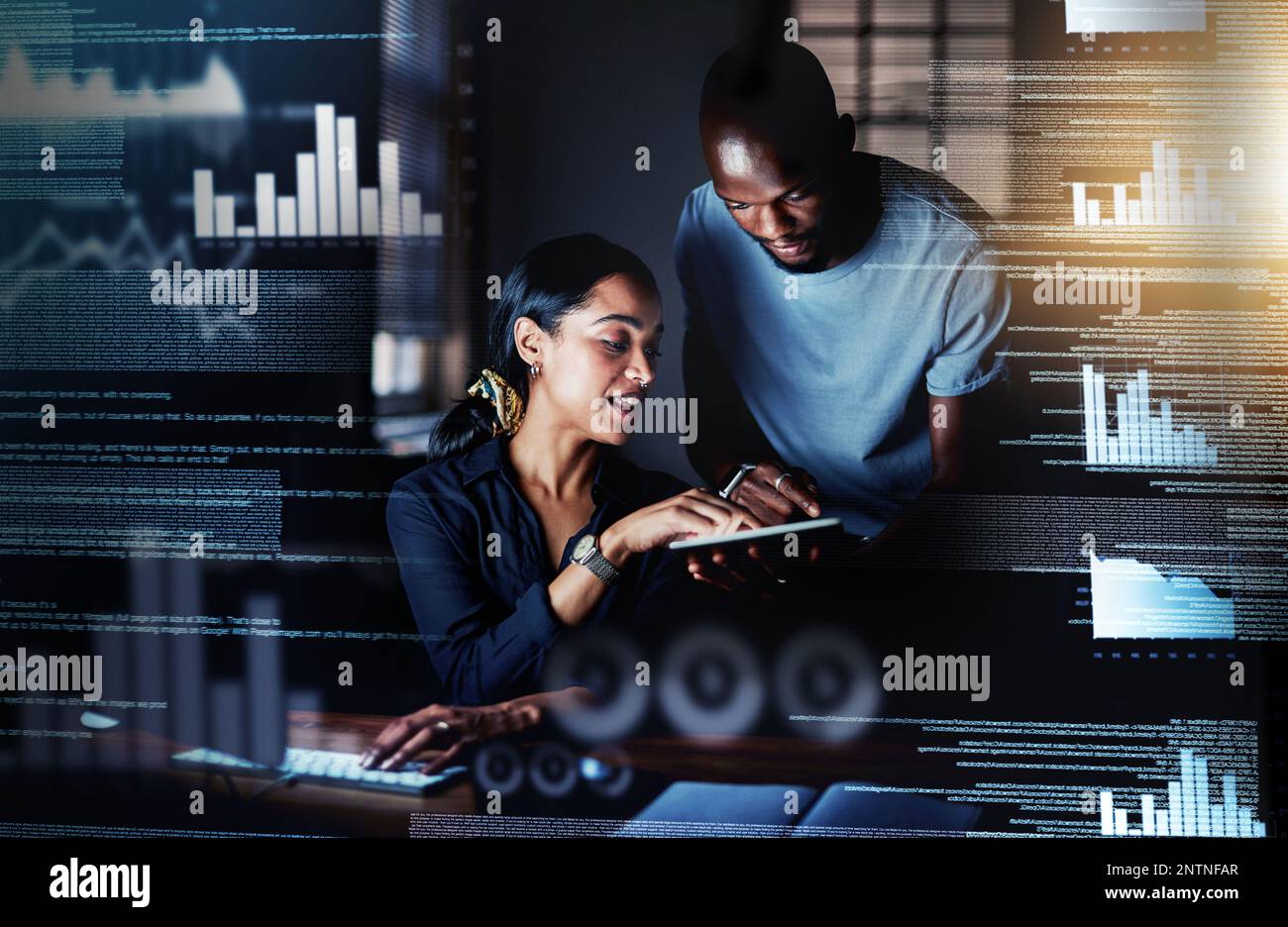 Adding modifications to their plans. Shot of two programmers using a digital tablet while working together on a computer code at night. Stock Photo