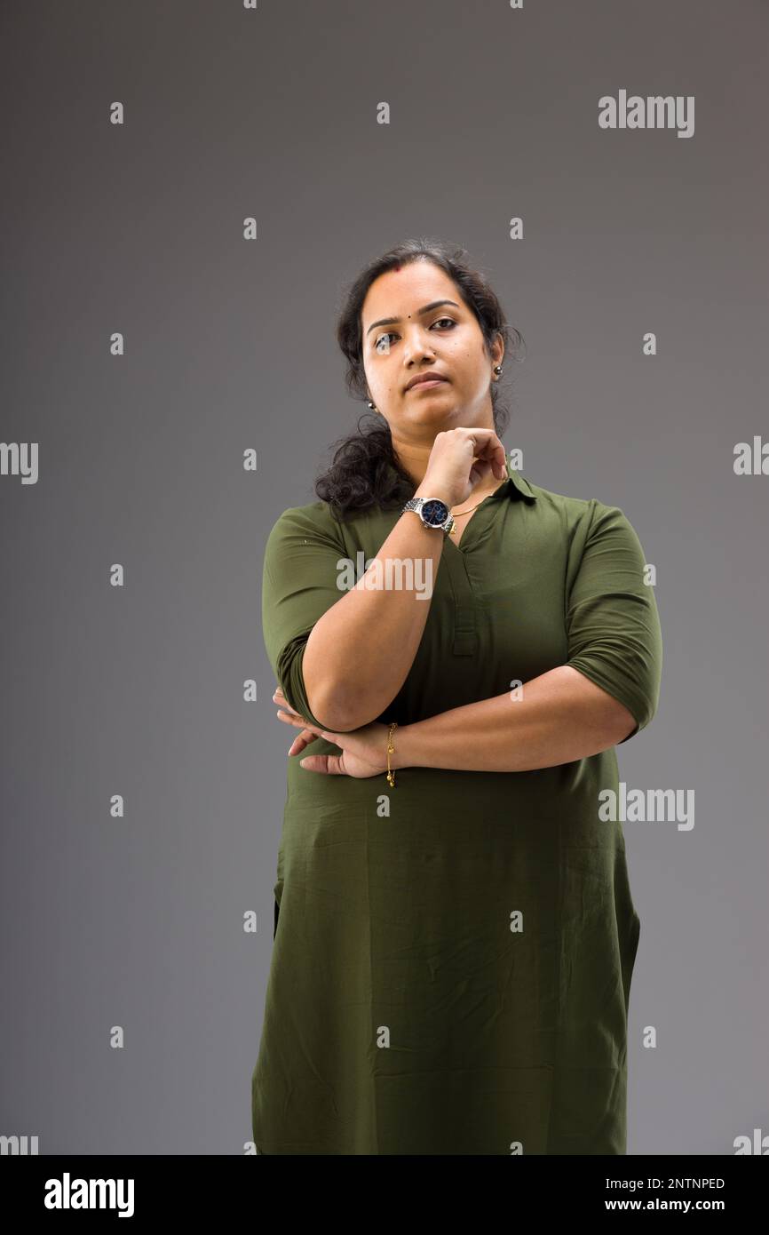 Portrait of an Indian woman,Standing pose showing different gesters, with grey background ,isolated. Stock Photo
