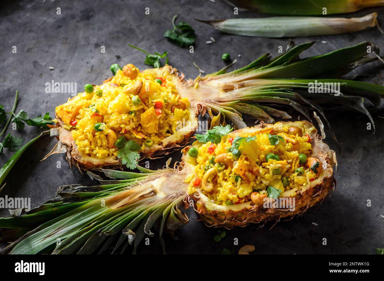Asian style rice in pineapple with eggs, peas, cashew and coriander on