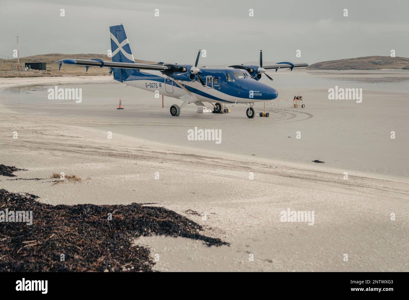 The Twin Otter aircraft is seen on Traigh Mhòr beach on Barra in the Scottish Outer Hebrides. The service is the only scheduled beach service in the w Stock Photo