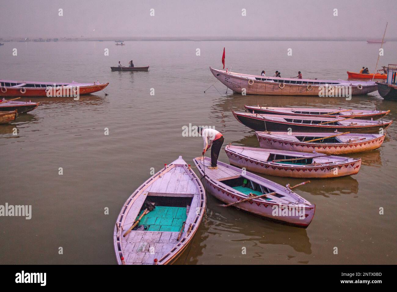 Fisherman, in background boats of tourists, in Ganges river, Varanasi, Uttar Pradesh, India. Stock Photo