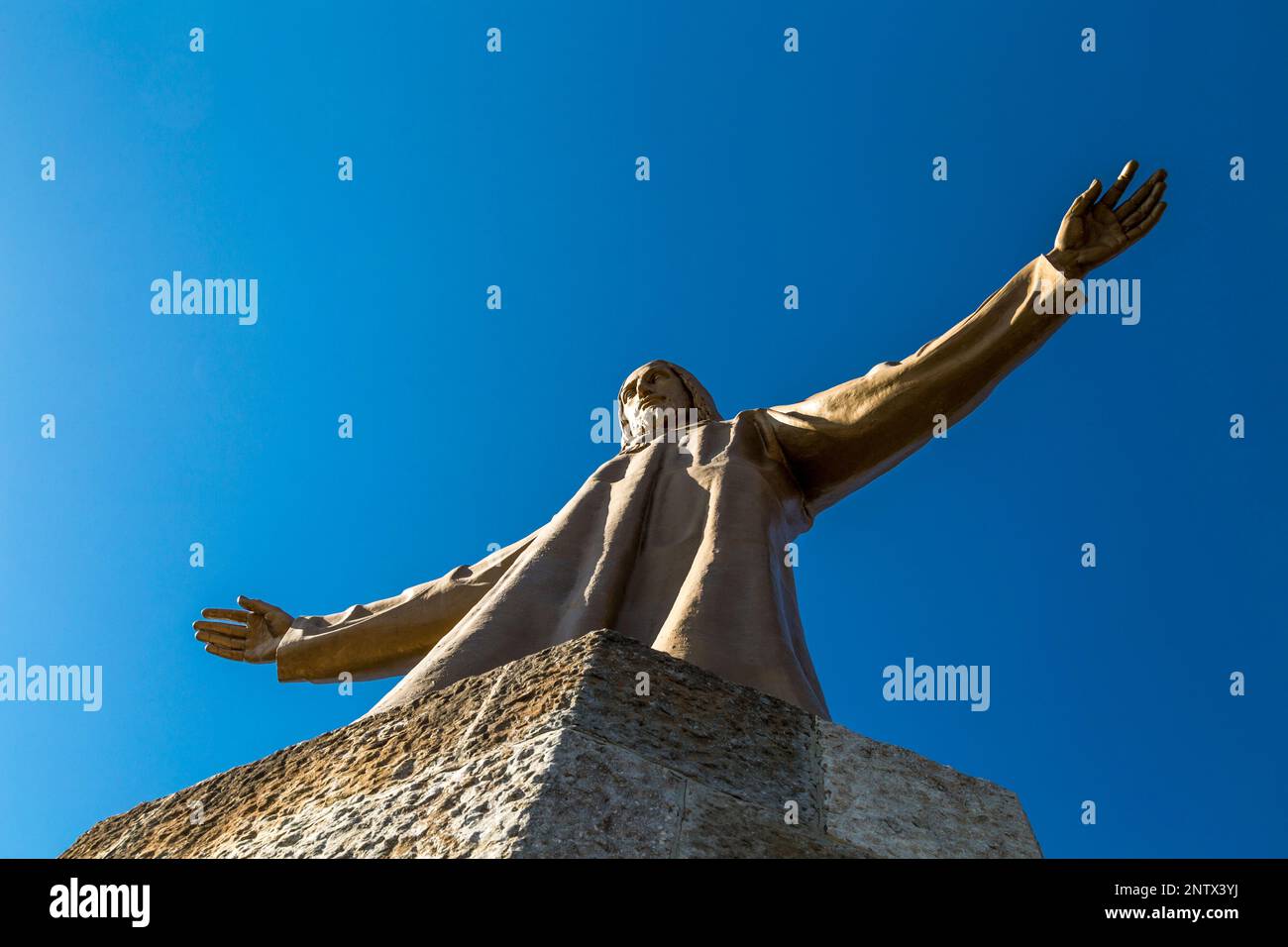 Bronze statue of Jesus (1950) by Josep Miret at the top of Temple of the Sacred Heart of Jesus church, Barcelona, Spain Stock Photo