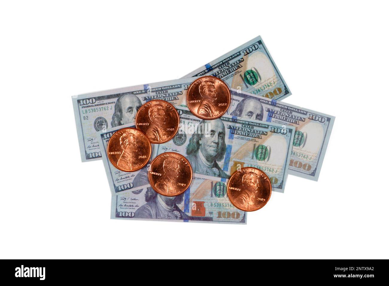 Dollars and cents. American pennies on top of miniature replica one hundred dollar bills cutout on a white background for editorial, illustrative use Stock Photo