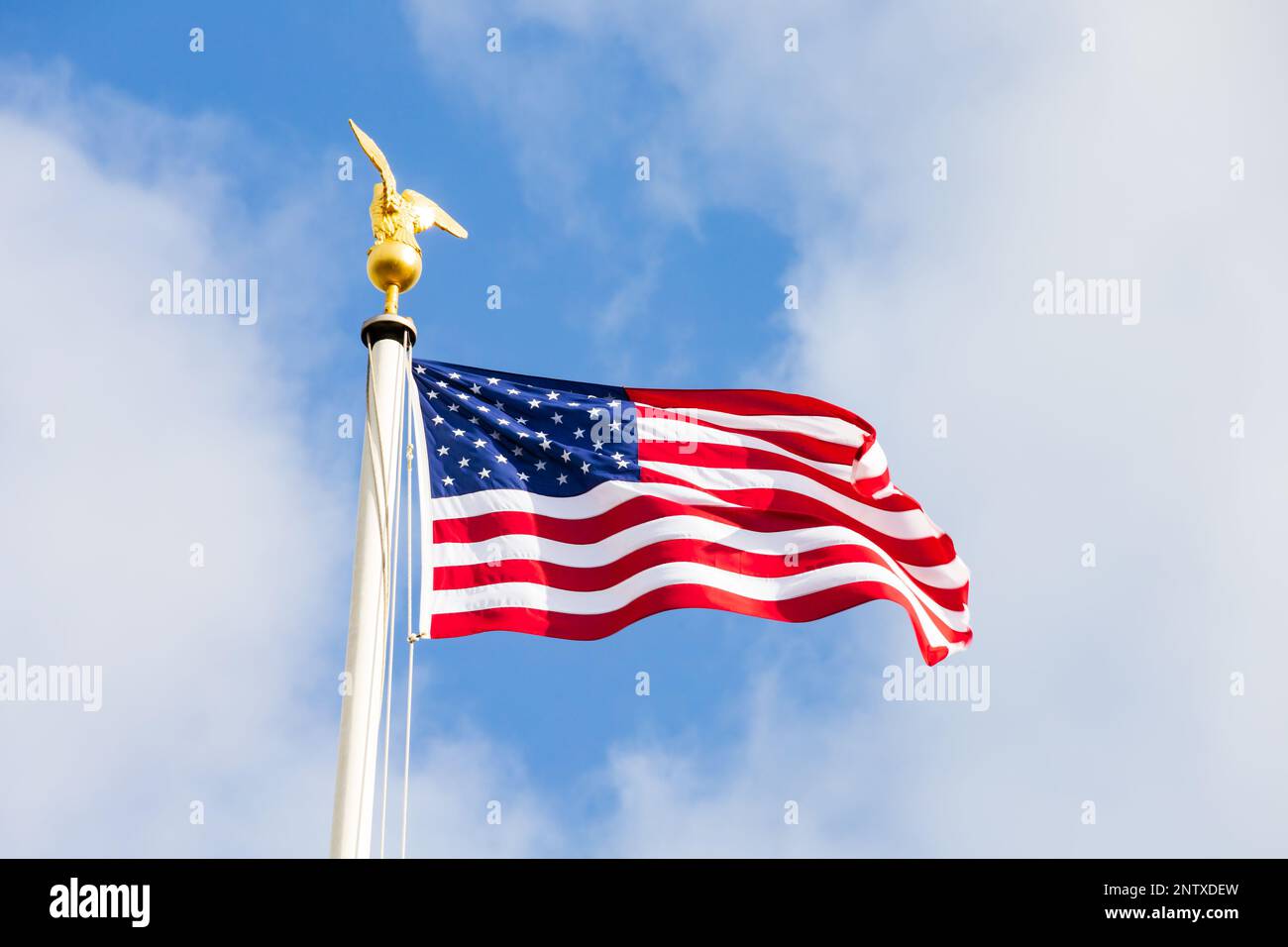 Stars and Stripes flag with gold eagle masthead flying over the Cambridge American Cemetery and Memorial, Madingley, Cambridgeshire, England Stock Photo