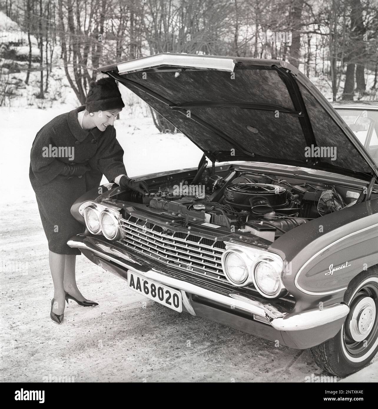 In the 1960s. A young woman in the winter with her brand new car, an american Buick Special 1961.  She looks happy and is dressed in warm winter clothes. Sweden 1961. Kristoffersson ref CS5-4 Stock Photo