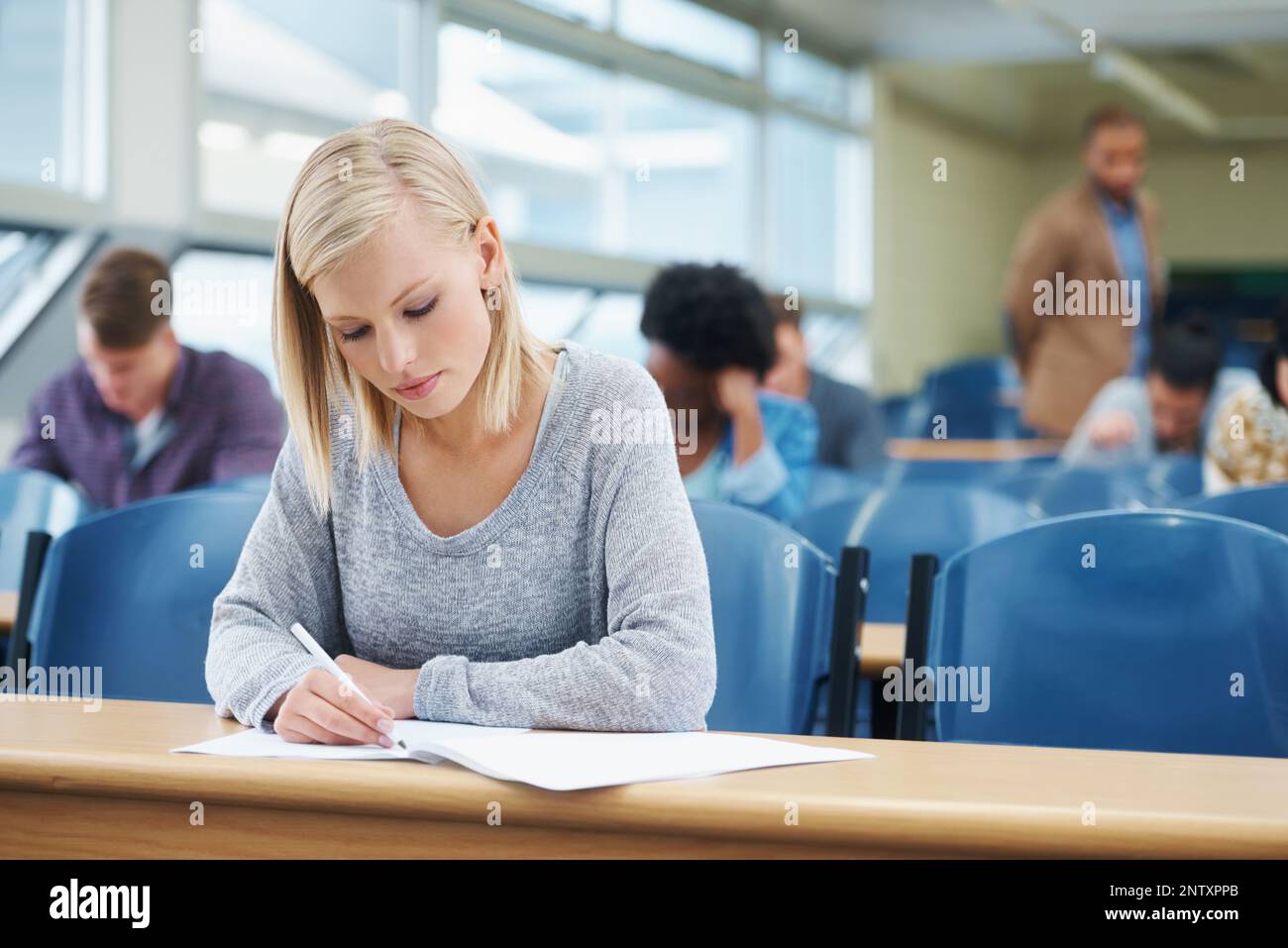 The last exam before the real world begins. Shot of a group of university students sitting in a lecture. Stock Photo
