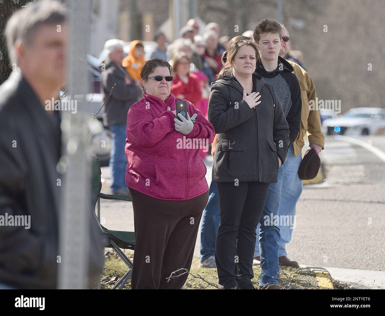 Mourners stand in silence as the funeral procession of fallen Virginia