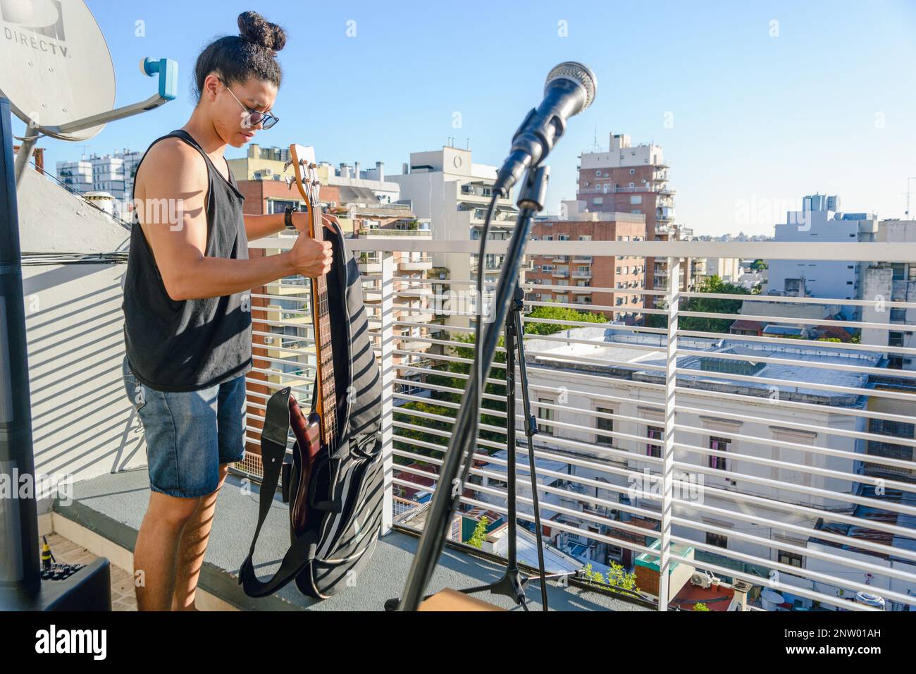 Male sound technician installing a set for an acoustic recital on a