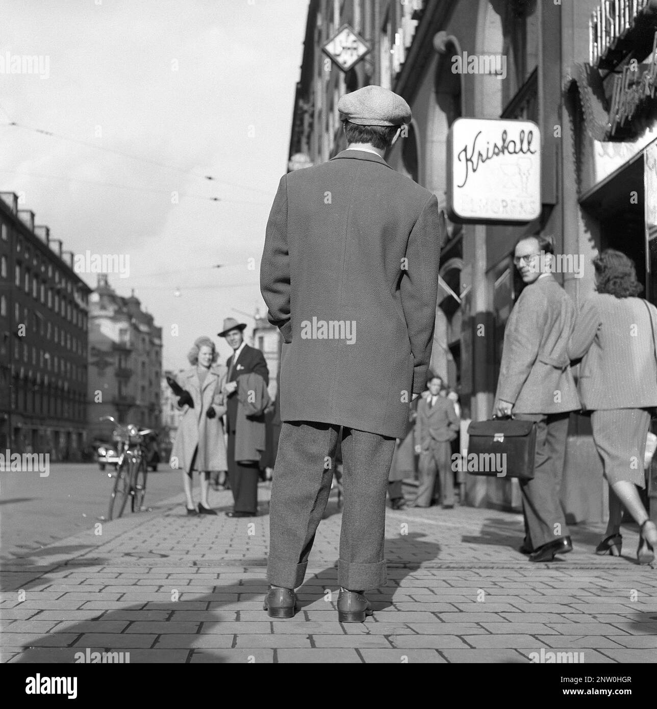 1940s fashion. A young man wearing the typical Zoot suit, a men's suit with high-waisted, wide-legged trousers and a long coat with wide lapels and wide padded shoulders. The zoot suit was controversial in the 1940s. The word Zoot probably comes from a reduplication of suit.  The front side is seen on picutre KG271202.   Sweden 1944 Kristoffersson Ref K60-1 Stock Photo