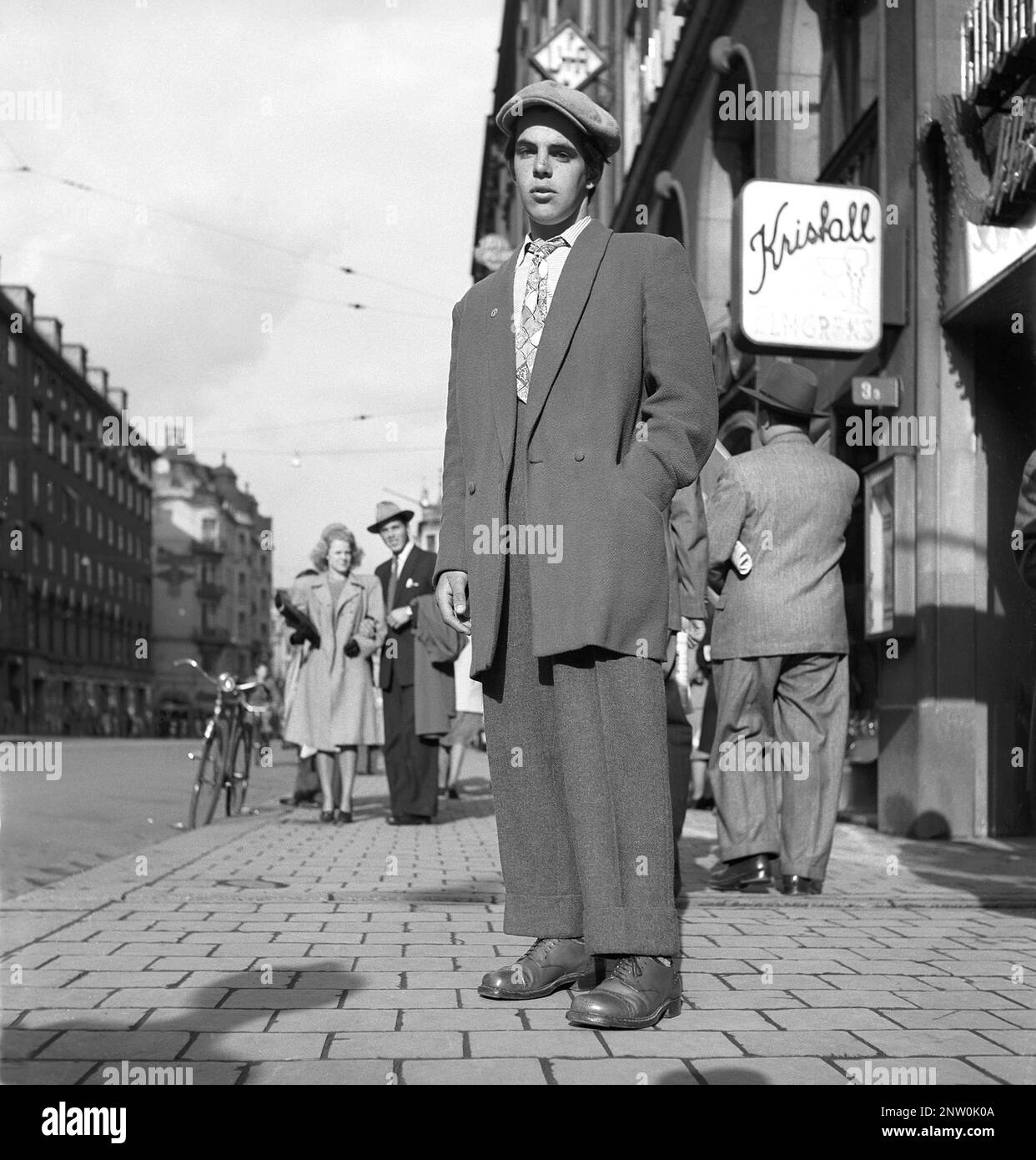 1940s fashion. A young man wearing the typical Zoot suit, a men's suit with high-waisted, wide-legged trousers and a long coat with wide lapels and wide padded shoulders. The zoot suit was controversial in the 1940s. The word Zoot probably comes from a reduplication of suit.  The back side of the zoot suit is seen on picutre KG271200.   Sweden 1944 Kristoffersson Ref K60-2 Stock Photo