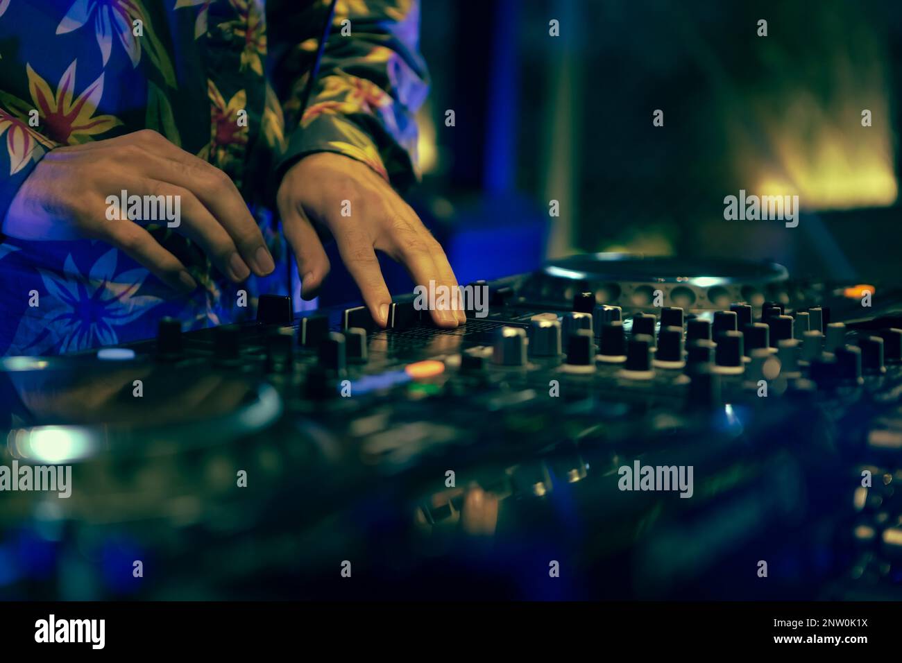 Club DJ playing music with sound mixer and cd turntables. Disc jockey