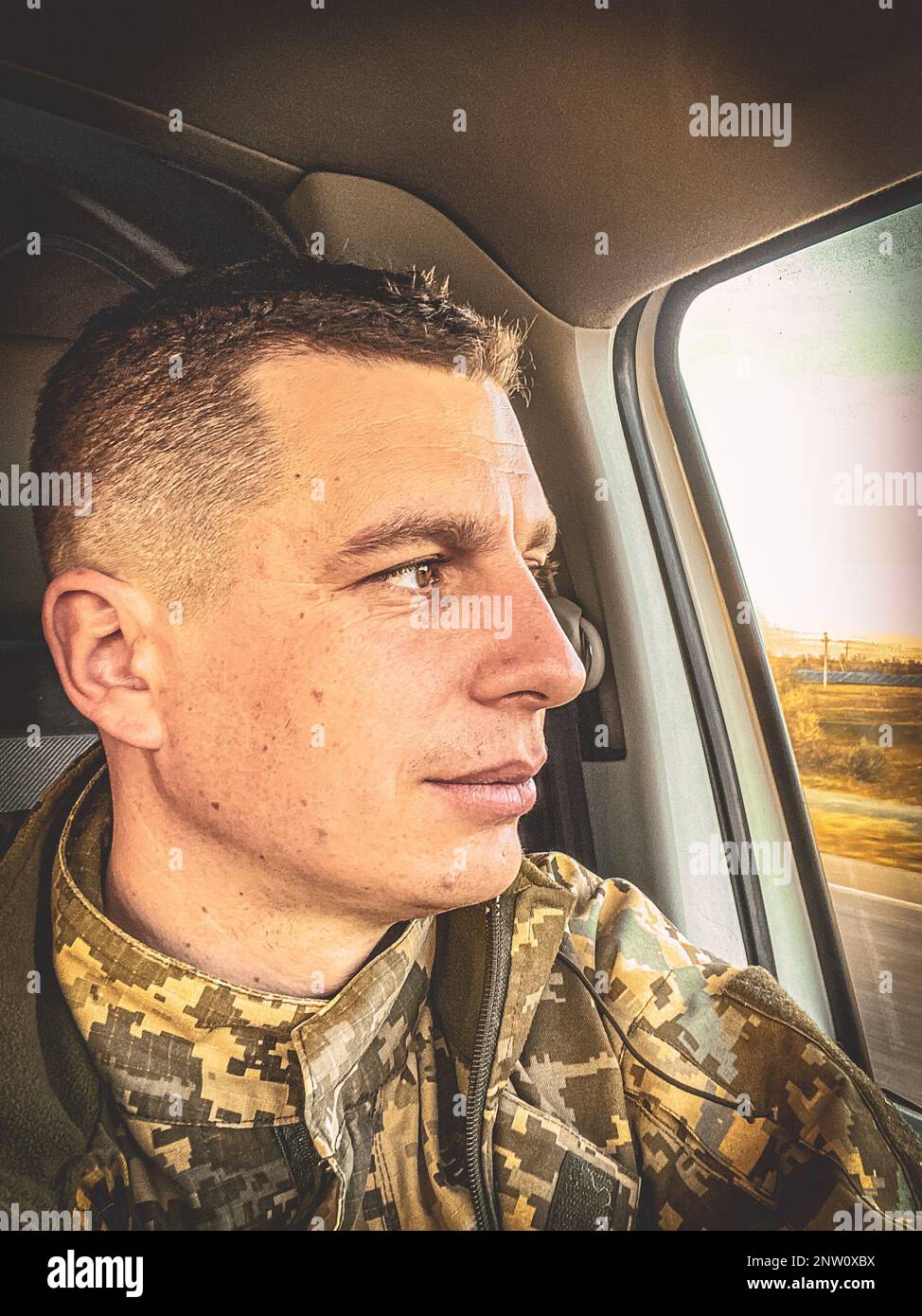 37 year old Ukrainian soldier in full military uniform, sitting calmly in a  car and gazing out the window. The man eyes are confident, calm and focused  Stock Photo - Alamy
