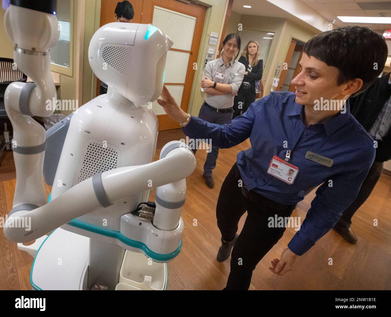In this on Monday, Jan. 21, 2019 photo, Agata Rozga, of Diligent Robotics,  points out features on the company's medical assistant robot, Moxi, in a  hallway at the University of Texas Medical