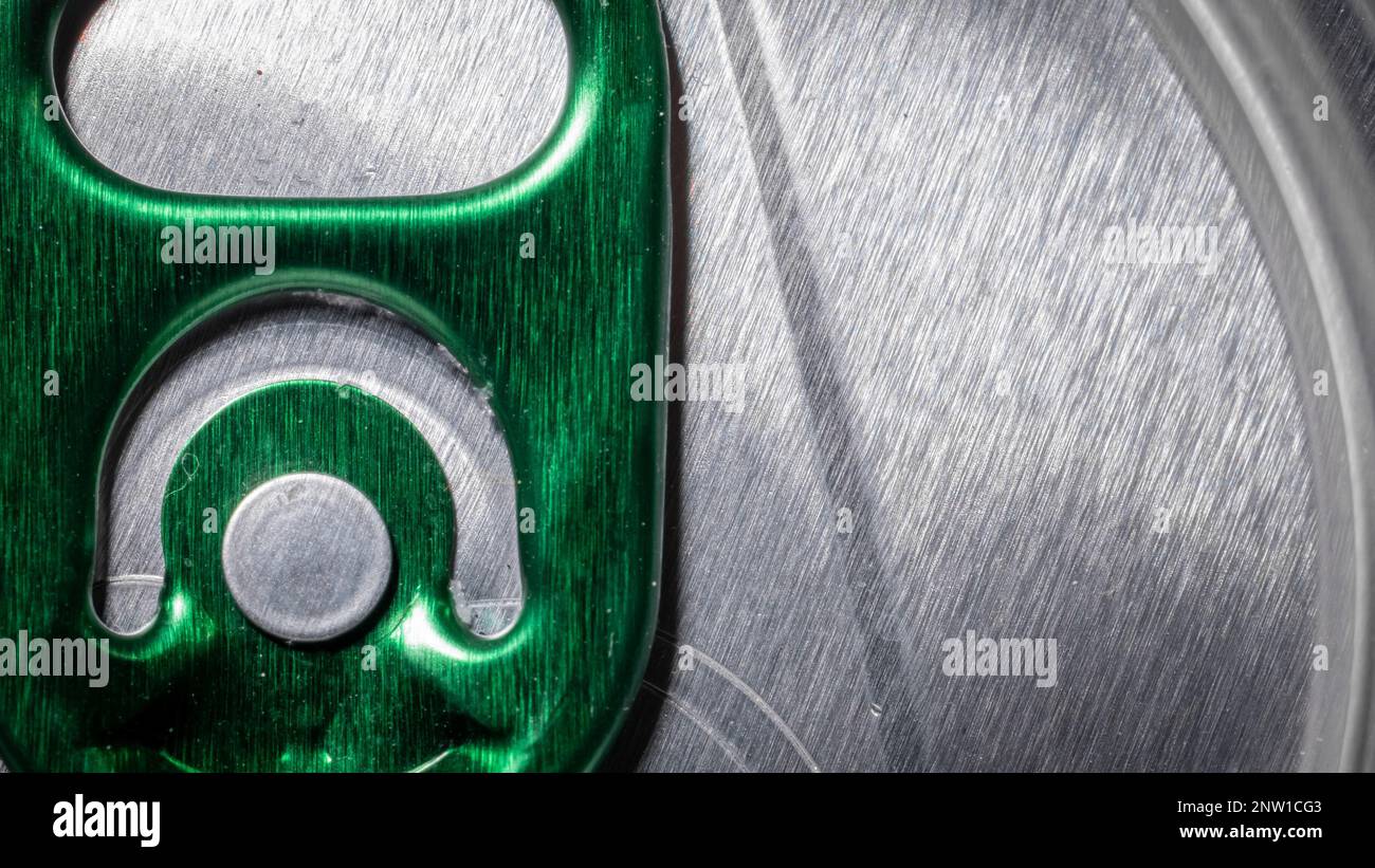 Macro or detail photo of an aluminium can with ring pull in green color. Frontal view of a can