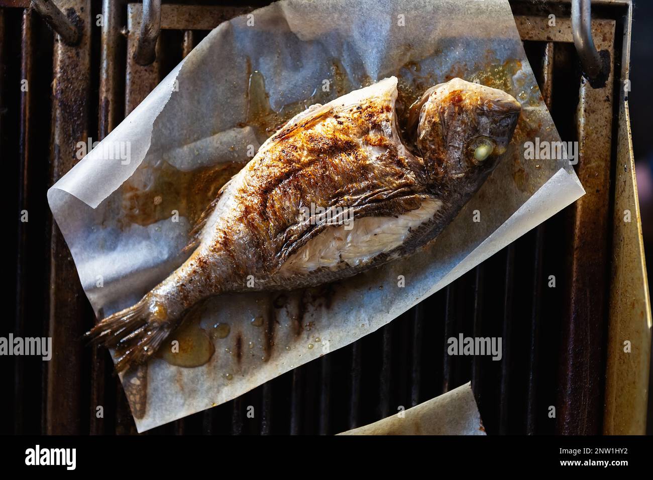 Delicious dorado fish cooking on grill. Whole mahimahi fish being