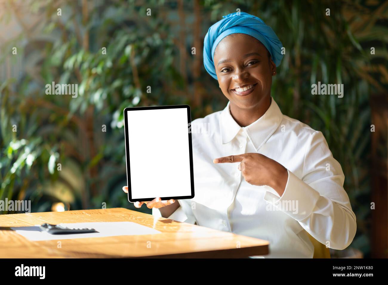 Cheerful african american woman showing digital pad with empty screen ...