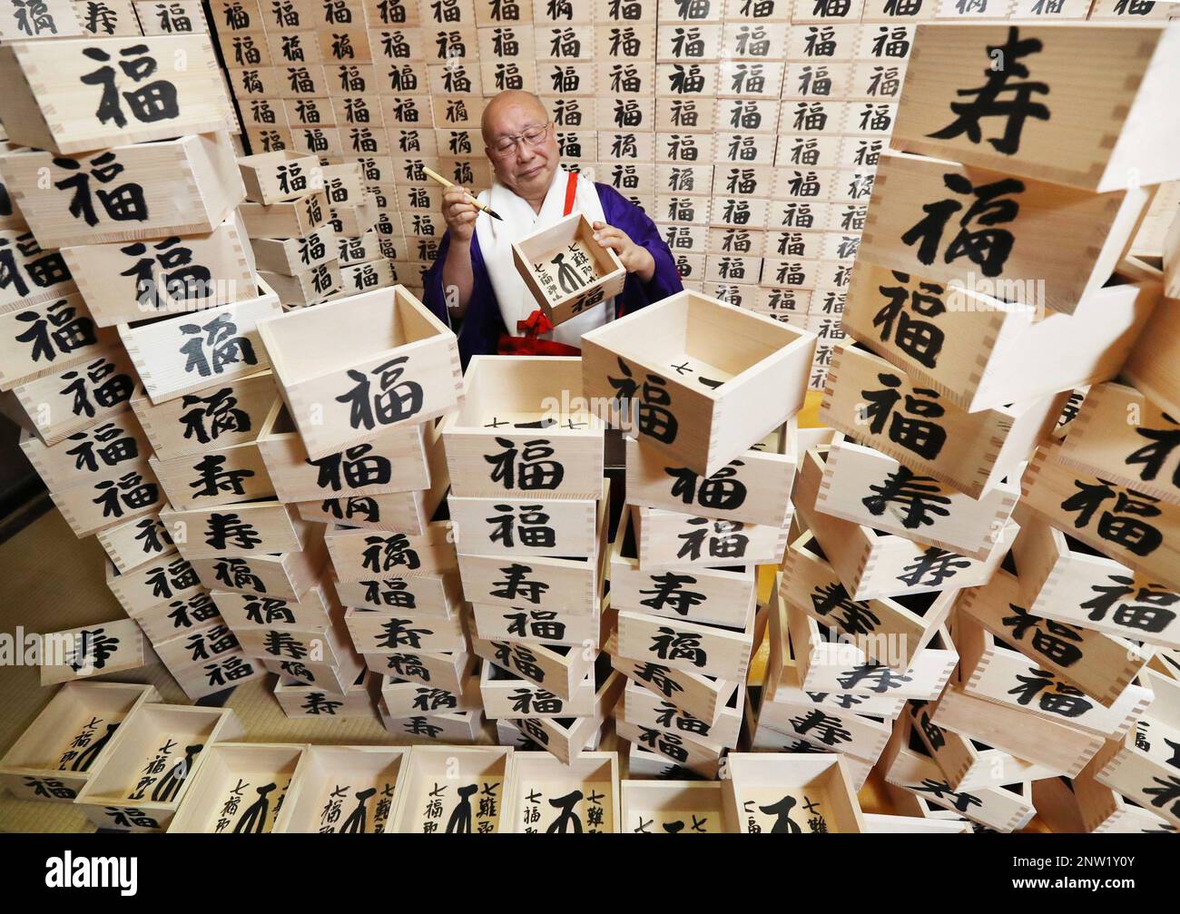 A monk writes fuku (happiness) and kotobuki (congratulation) by kanji