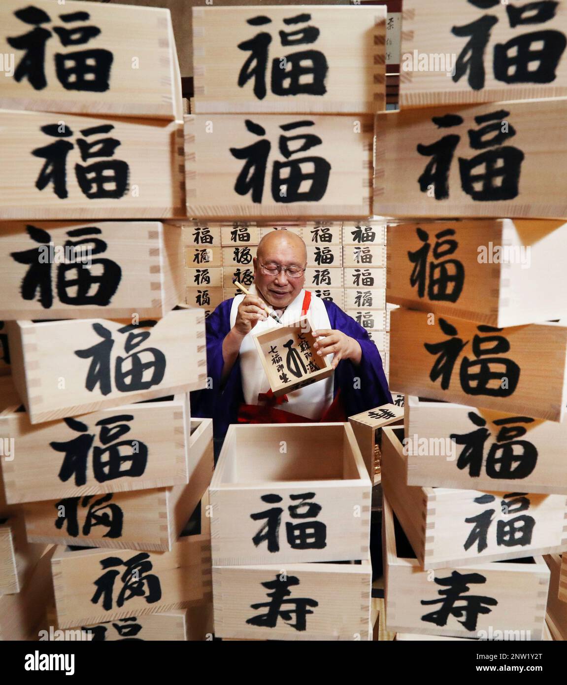 A monk writes fuku (happiness) and kotobuki (congratulation) by kanji