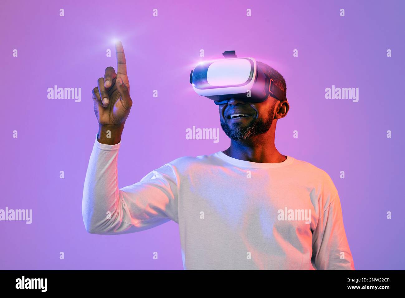 Black man in VR headset touching something invisible Stock Photo
